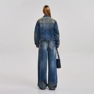 Vista posteriore dettagliata del set in denim blu lavato con giacca e pantaloni effetto usurato