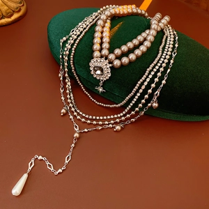 Detail of multi-layer pearl necklace with crystal clasp and pearl pendant on velvet