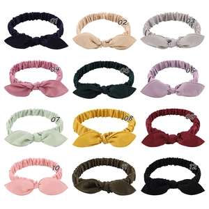 Macro display of 12 colorful elastic bow headbands for babies in a 3x4 grid layout