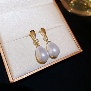 Detail of elegant teardrop pearl earrings with gold hardware in a premium jewelry box