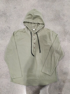 Close-up of olive green linen hoodie shirt with button placket and black drawstring