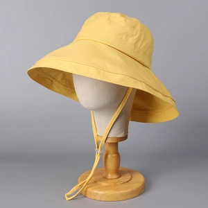 Detail of yellow cotton sun hat with wide brim and adjustable drawstring wind cord