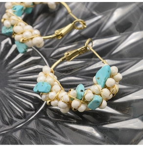 Detail of handmade gold wire-wrapped hoop earrings with white pearls and blue turquoise stones