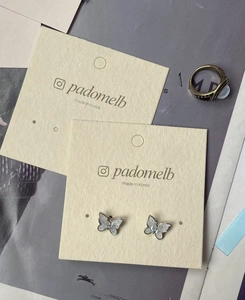 Macro detail of butterfly stud earrings with pearl shell inlay on jewelry card