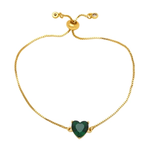 Dettaglio di un bracciale con cuore in zircone verde e chiusura a catena dorata