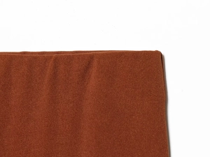 Macro detail of caramel brown knitted fabric texture and premium stitching on the trousers