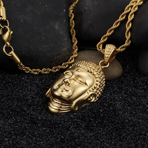 Macro detail of a 3D gold Buddha head pendant with a matching twisted rope chain