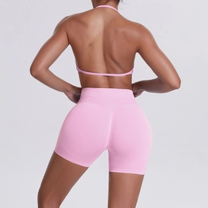 Pink seamless yoga set with halter neck open back top and high-waist lifting shorts