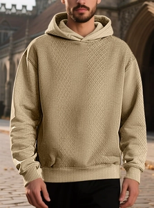 Close-up of khaki waffle knit hoodie showing textured diamond pattern and ribbed cuffs