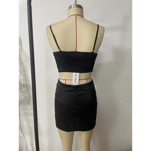 Détail d'un ensemble deux pièces noir avec crop top froncé et mini-jupe ajustée