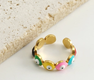 Detailed view of gold evil eye ring with multi-color enamel on travertine stone