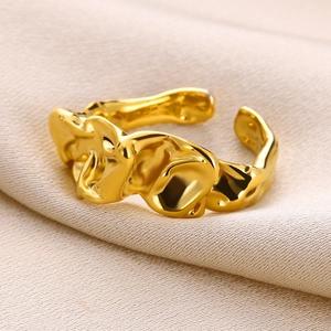 Macro detail of gold-plated heart ring featuring unique molten lava texture and open design