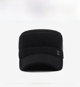 Front view of black flat top military cap showing textured wool fabric and metal logo