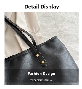 Detail of black PU leather tote bag with natural grain texture and gold metal rivets