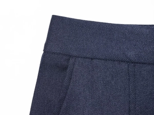 Détail de la texture en sergé bleu foncé et des coutures de la taille du pantalon