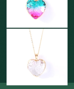 Detail of colorful heart crystal pendants with gold edges on delicate gold chains