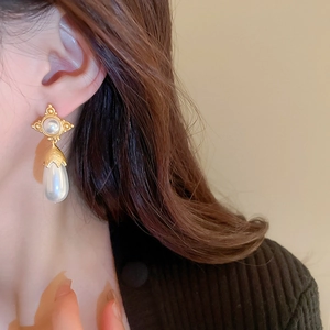 Détail de boucles d'oreilles vintage en perles avec motif étoile sur un mannequin