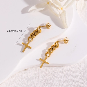 Chic gold cross chain drop earrings with punk tassels on a minimalist display