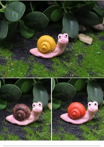 Three colorful resin snails in yellow, brown, and orange for moss micro-landscape decor