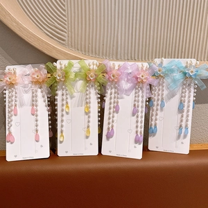 Close-up of traditional flower hair clips with silk ribbons and pearl tassels in four colors