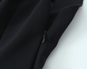 Detail of invisible zipper and fine stitching on a black stretch peplum vest top