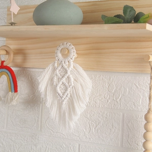 Close-up of handmade white cotton rope wall hanging in a leaf feather woven pattern