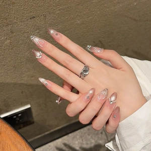 Pink cat-eye press-on nails with pearls, silver details, and long almond shape design