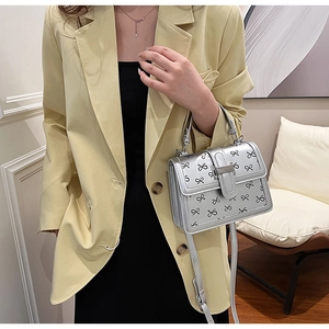 Borsa a mano quadrata argento con fiocchi neri, dotata di manico e tracolla alla moda