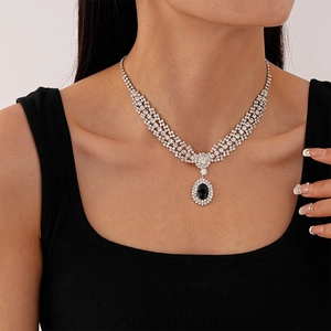 Vue détaillée du collier de luxe avec une grande pierre noire ovale et des chaînes de zircons