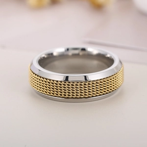 Détail d'une bague rotative en acier inoxydable bicolore avec maille dorée tressée