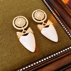 Detail of vintage style gold bow earrings with crystal inlay on green velvet display
