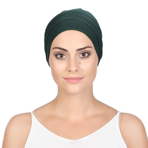Front view of dark green pleated turban hat showing fabric texture and elegant folds