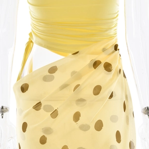 Détail du haut bandeau jaune et jupe à pois avec texture drapée effet portefeuille