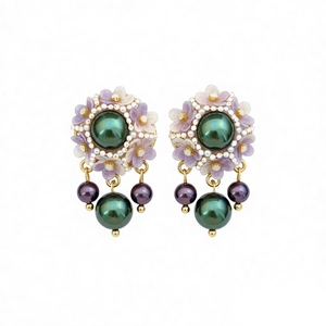 Vintage green resin flower earrings with pearls and gold metal base on white backdrop