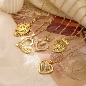 Close-up of five assorted gold heart necklaces with zircon inlays and crown details