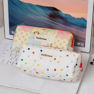 Detail of quilted cotton pencil case with floral patterns and woven house label