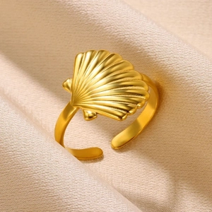 Detailed close-up of 18K gold plated starfish shell ring on a beige silk background