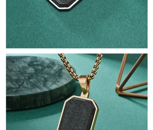Detail of forged carbon fiber pendant with gold trim and stainless steel box chain