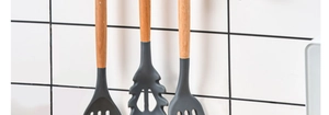 Detail of multi-functional silicone kitchen utensils with wooden handles hanging on hooks