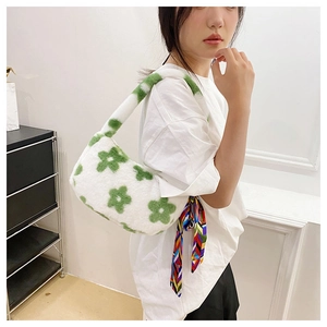 Detail of white plush shoulder bag with green floral pattern and silk scarf accessory