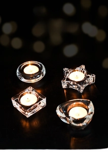 Detail of high transparency glass tea light holders in geometric star and heart shapes
