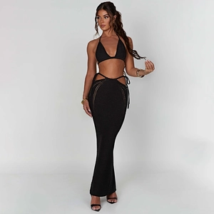 Dettaglio del set due pezzi in maglia nera con top bikini a fascia e gonna lunga a pieghe