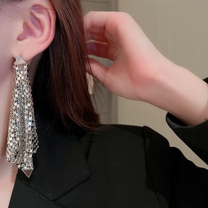 Gros plan de boucles d'oreilles argentées à maille triangulaire sur un mannequin