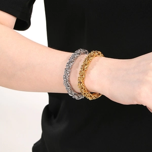 Macro view of interwoven metal links in gold and silver finish on a wide chain bracelet