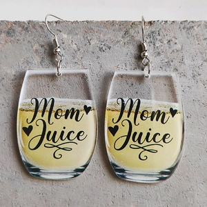 Close-up of Mom Juice lettered yellow acrylic wine glass earrings on a concrete surface