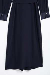 Detail of dark blue dress sleeve showing glossy cuffs and golden button accents