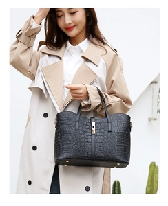 Fashionable black crocodile pattern tote bag with gold hardware shown on a model