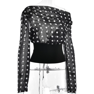 Detailed view of the sheer mesh sleeves and black elastic waistband on the polka dot top