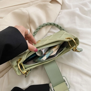 Quilted light green baguette bag with woven handle showing interior storage capacity