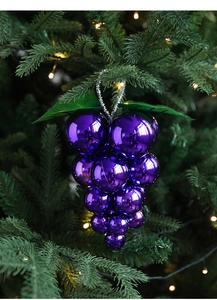 Purple grape-shaped Christmas ornament with glossy finish and green leaves on a tree